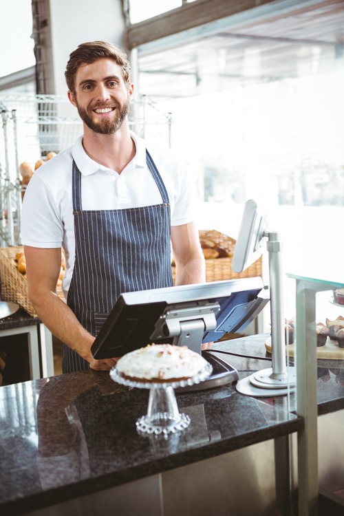 Smiling worker posing behind the counter at the bakery